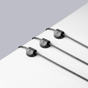 Example of three cord holders on workstation surface holding wires
