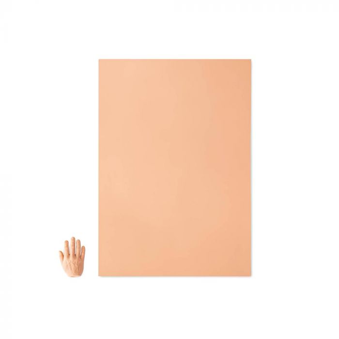 Pink-toned tattooable flesh in the shape of a rectangle laying next to a hand for size reference on a white background.