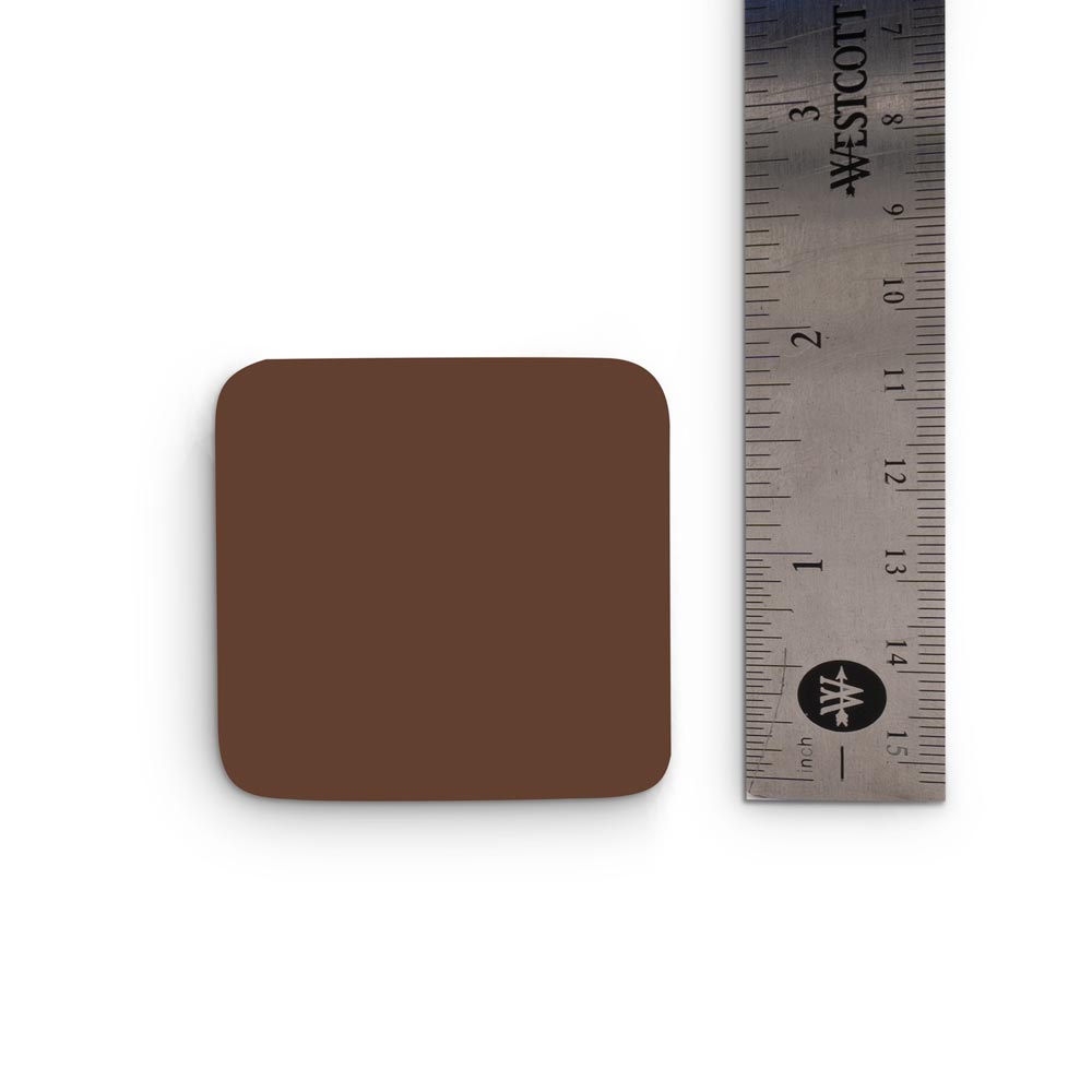 Dark-toned tattooable flesh sample square next to a steel ruler on a white background. The square reaches the 2" mark on the ruler.