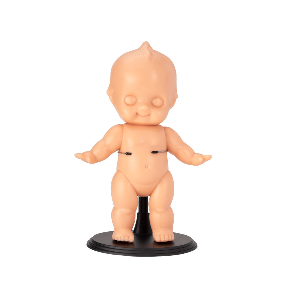 Light-toned tattooable cutie doll on a black stand with a white background.