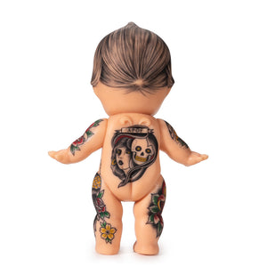 Light-toned tattooable cutie doll with American-traditional tattooes backwards-facing with a white background.