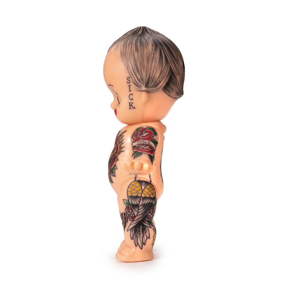 Light-toned tattooable cutie doll with American-traditional tattooes side-facing with a white background.