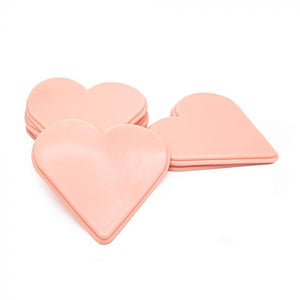 Three light-toned tattooable flesh in the shape of stylized hearts on a white background.