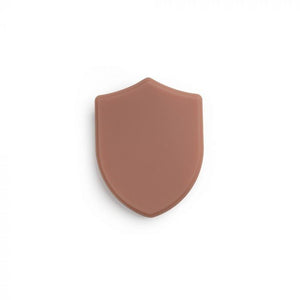 Medium-toned tattooable flesh in the shape of a shield on a white background.