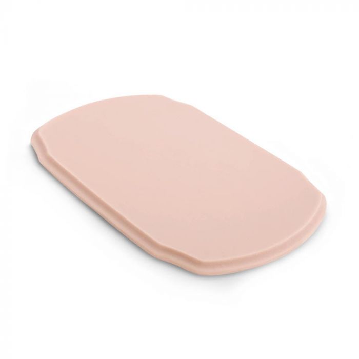 Pink-toned tattooable flesh in the shape of a rounded plaque on a white background.