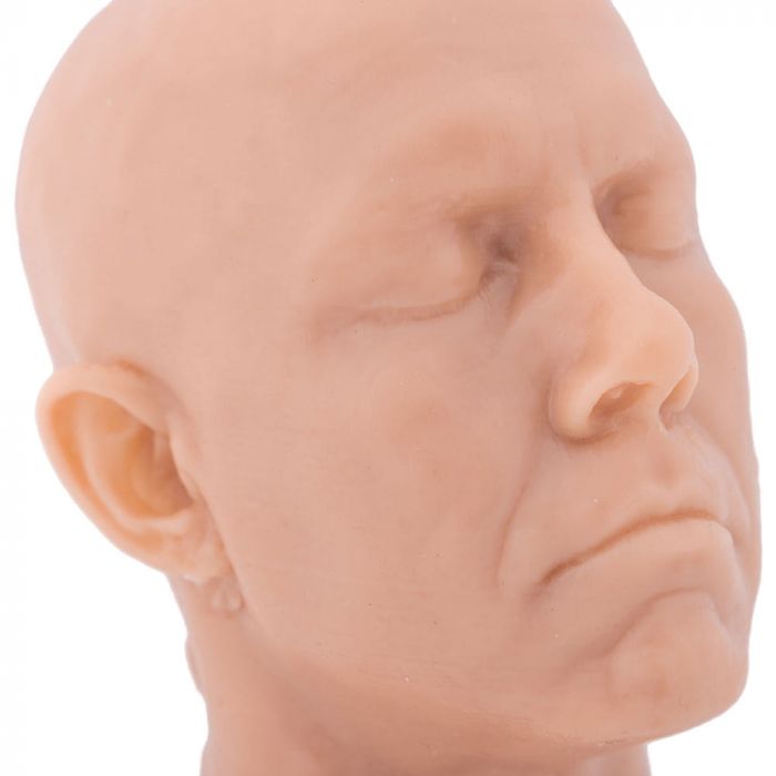 Close-up of light-toned tattooable flesh in the shape of a man's head and neck on a white background. The head is diagonally-facing.