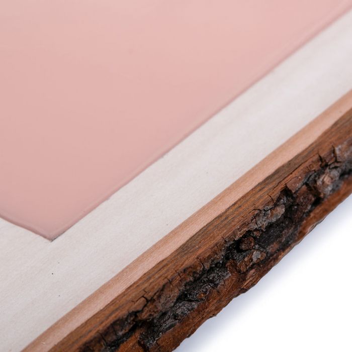 Closeup shot of a light-skin-toned tattooable canvas imbedded in a rectangle slab of wood.