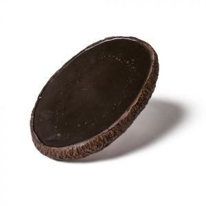 The black back-side of tattooable flesh designed to look like a slab of wood cut from a branch. This product is posed in front of a white background. 